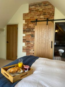 a tray of bread and orange juice on a bed at Beautiful 3 bed cottage in Lymington. Perfectly located for Coast and New Forest in Lymington