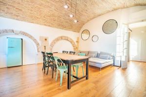 ein Wohnzimmer mit einem Tisch, Stühlen und einem Sofa in der Unterkunft Archi di Castello, Storia e Design 3Br-WiFi-AC in Cagliari