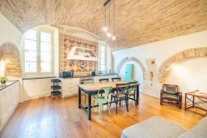 eine Küche und ein Esszimmer mit einem Tisch und Stühlen in der Unterkunft Archi di Castello, Storia e Design 3Br-WiFi-AC in Cagliari