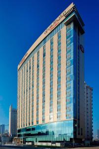 un grand bâtiment avec un panneau en haut dans l'établissement Residence Inn by Marriott Kuwait City, à Koweït