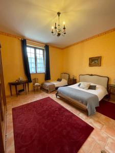 a bedroom with two beds and a red rug at Le Château de Quinéville in Quinéville
