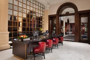 a lobby with a reception desk and red chairs at The US Grant, a Luxury Collection Hotel, San Diego in San Diego