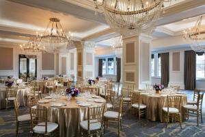 un salón de banquetes con mesas, sillas y lámparas de araña en The US Grant, a Luxury Collection Hotel, San Diego, en San Diego