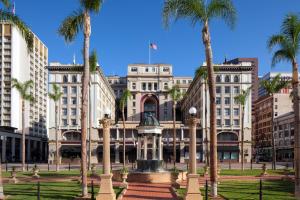 サンディエゴにあるジ US グラント ア ラグジュアリー コレクション ホテル サンディエゴのヤシの木が目の前に広がる建物