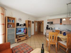 a living room with a couch and a tv and a kitchen at Hoppenberg in Zingst