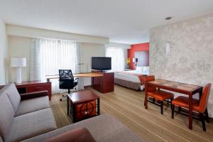 Habitación de hotel con cama y sala de estar. en Residence Inn Lansing West, en Delta Center Township