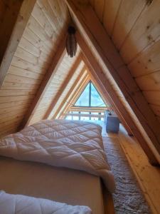 ein Schlafzimmer mit einem Bett im Dachgeschoss in der Unterkunft Waterfall A Frame, Maramures in Baia Mare