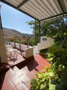 a patio with a deck with a view of a mountain at B&B and Apartments El Charco Azul in El Risco