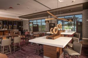 um restaurante com mesas e cadeiras e um bar em Courtyard by Marriott Boston Littleton em Littleton