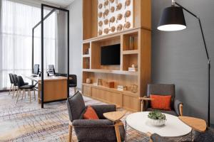 a living room with a table and chairs at Delta Hotels by Marriott Green Bay in Green Bay