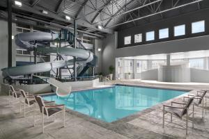 a swimming pool with a slide in a building at Delta Hotels by Marriott Green Bay in Green Bay