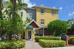 TownePlace Suites Miami Lakes في ميامي ليكس: مبنى اصفر امامه رصيف