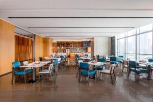 un comedor con mesas y sillas azules en Fairfield by Marriott Foshan Nanhai en Foshan