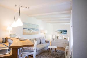 Kleines-Versteck في فيسترلاند: مطبخ وغرفة معيشة مع طاولة وأريكة