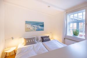 Kleines-Versteck في فيسترلاند: غرفة نوم بيضاء مع سرير ونافذة