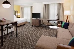 una camera d'albergo con divano, letto e scrivania di Residence Inn Boston Dedham a Dedham