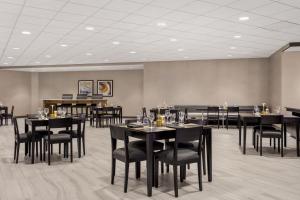 uma sala de jantar com mesas e cadeiras pretas em Delta Hotels by Marriott Somerset em Somerset