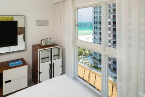 sypialnia z dużym oknem z widokiem na plażę w obiekcie Royal Palm South Beach Miami, a Tribute Portfolio Resort w Miami Beach