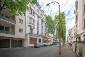 ulica z samochodami zaparkowanymi po bokach budynków w obiekcie Le George V - Appartement centre ville et parking w mieście Vichy