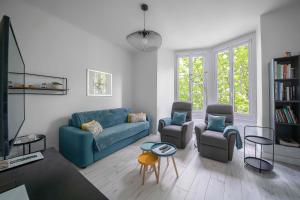 salon z niebieską kanapą i krzesłami w obiekcie Le George V - Appartement centre ville et parking w mieście Vichy