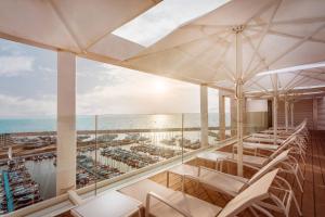 Un balcón con sillas blancas y vistas al océano. en The Ritz-Carlton, Herzliya en Herzelia 