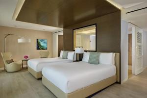 a hotel room with two beds and a mirror at The Ritz-Carlton, Herzliya in Herzliya