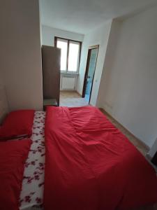 una camera con un grande letto rosso di Yellow house 1 a Cuasso Al Monte