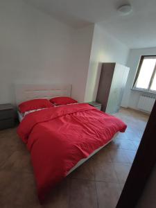 un letto rosso con due cuscini rossi in una camera da letto di Yellow house 1 a Cuasso Al Monte