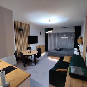 ein Hotelzimmer mit einem Bett, einem Sofa und einem Tisch in der Unterkunft Apartament Royal Solny Resort z aneksem kuchennym w hotelu z krytym basenem, sauną i usługami SPA in Kołobrzeg