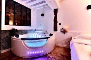 a bathroom with a bath tub with lights in it at Le Spa Beauvoisine - Jacuzzi Sauna Rouen centre Free parking in Rouen