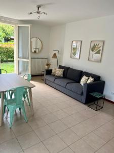 een woonkamer met een blauwe bank en een tafel bij giardino e piscina apartment in Bellagio