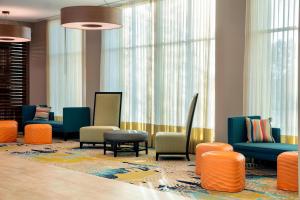 - une salle d'attente avec des chaises colorées et des fenêtres dans l'établissement TownePlace Suites by Marriott Orlando Theme Parks/Lake Buena Vista, à Orlando