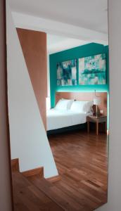 a bedroom with a white bed and a staircase at Principe Alogna Hotel & SPA in Altavilla Milicia