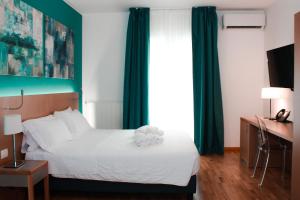 a hotel room with a bed with a teddy bear on it at Principe Alogna Hotel & SPA in Altavilla Milicia