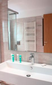 a bathroom with a white sink with a mirror at Principe Alogna Hotel & SPA in Altavilla Milicia