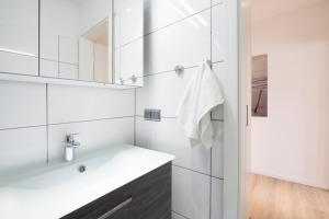 Baño blanco con lavabo y espejo en Villa am Meer Pier 29, en Grömitz