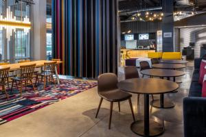 a group of tables and chairs in a room at Aloft Charlotte Ballantyne in Charlotte