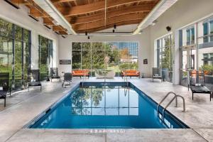 an indoor pool with chairs and a table at Aloft Charlotte Ballantyne in Charlotte