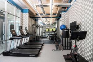 un gimnasio con cintas de correr y máquinas de ejercicio cardiovascular en Aloft Charlotte Ballantyne en Charlotte