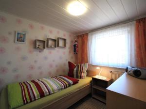 a small bedroom with a bed and a window at Schüler, Wolfgang in Zingst