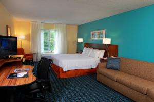 a hotel room with a bed and a couch at Fairfield Inn & Suites Traverse City in Traverse City