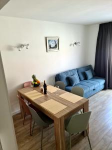 - un salon avec une table et un canapé bleu dans l'établissement Apartman Marko, à Nečujam