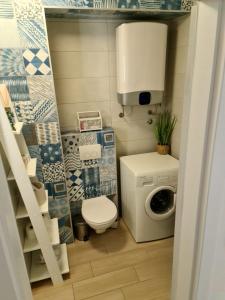 a small bathroom with a toilet and a washing machine at Apartman Marko in Nečujam