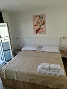 a bedroom with a large bed with two towels on it at Apartman Marko in Nečujam