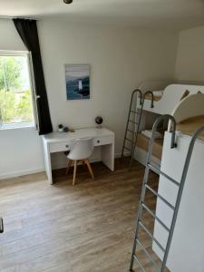 ein Schlafzimmer mit einem Etagenbett, einem Schreibtisch und einer Leiter in der Unterkunft Apartman Marko in Nečujam