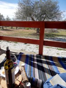 a bottle of wine sitting on a table with a fence at Burrico D`Orada - Lodging & Experiences in Pedrógão