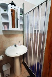 La salle de bains est pourvue d'un lavabo et d'une douche. dans l'établissement Appartamento Central, à Lipari