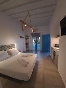 a bedroom with a large white bed and a kitchen at Bella Alba in Kalafatis