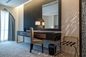 a desk with a mirror and a chair in a room at العنوان للشقق المخدومة-The Address Residence in Al Khobar