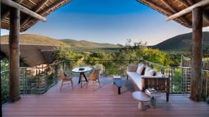 a deck with a couch and chairs and a table at Babohi at Qwabi Private Game Reserve by NEWMARK in Bela-Bela